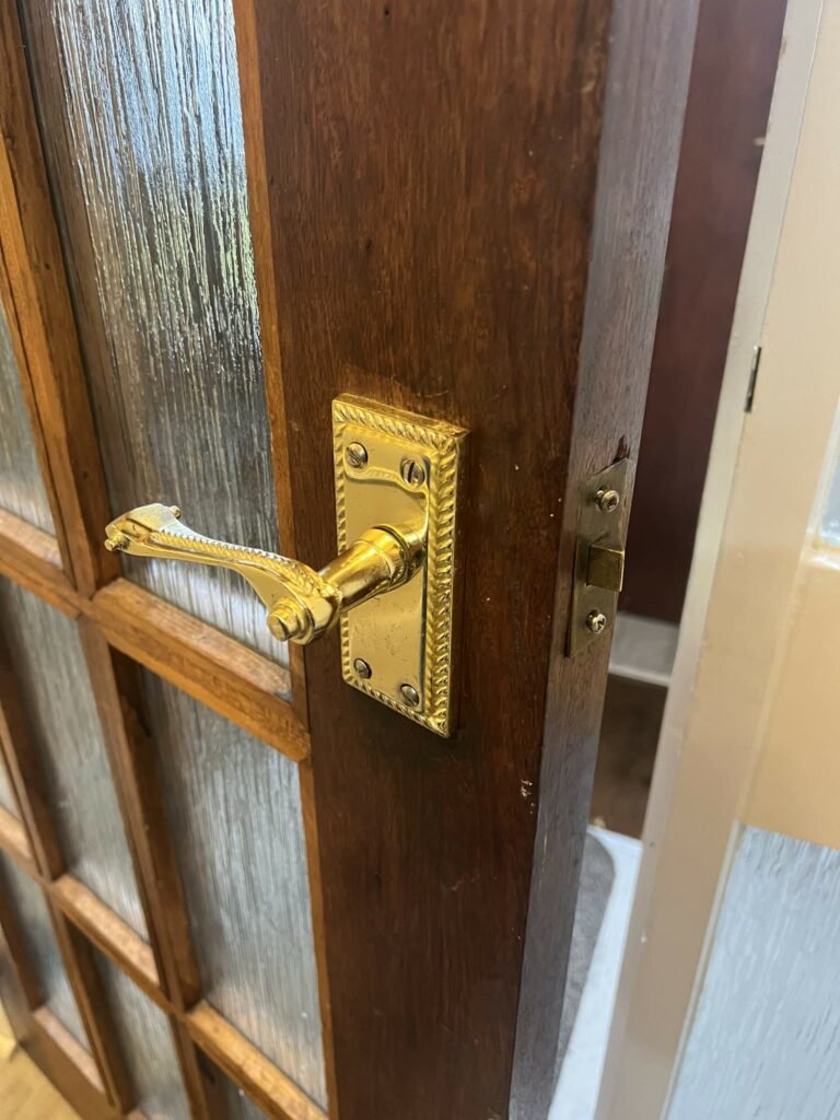 Handyman fixing a door handle inside a home.